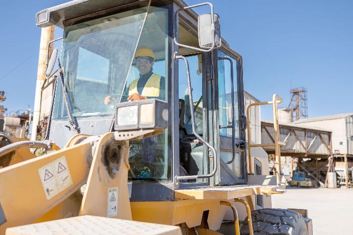 Trabajadora dirigiendo un vehículo pesado de obra