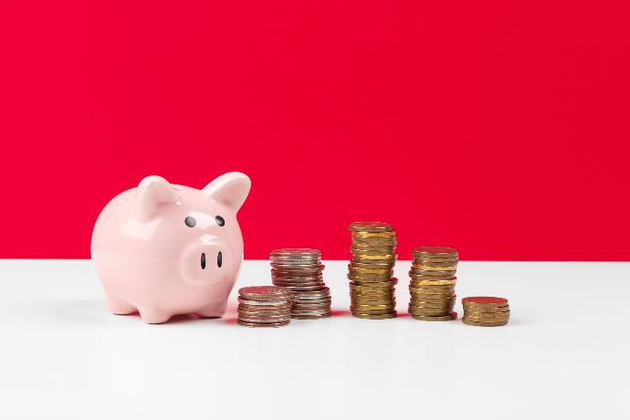 Reclamaciones económico administrativas Hucha con monedas bajo un fondo rojo y blanco