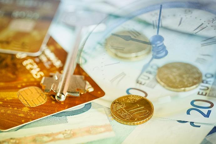 Liquidación de Plusvalía municipal Monedas y billetes de euro junto a tarjetas de crédito o débito